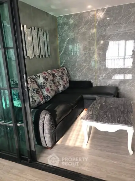 Stylish living room with modern decor and elegant marble wall accents.