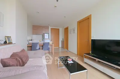 Modern living room with cozy sofa and sleek TV setup in open layout apartment.