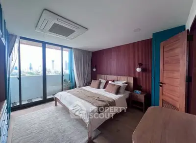 Modern bedroom with city view and balcony access, featuring stylish decor and ample natural light.