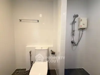 Modern bathroom with sleek white tiles and essential fixtures.