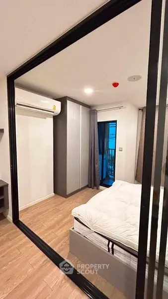 Modern bedroom with sleek design and balcony access in a stylish apartment.