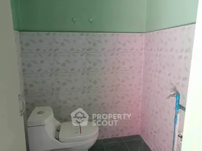 Spacious bathroom with modern toilet and tiled walls in a serene setting.