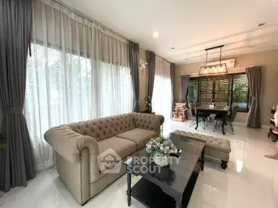 Elegant living room with plush sofa, chic dining area, and large windows for natural light.