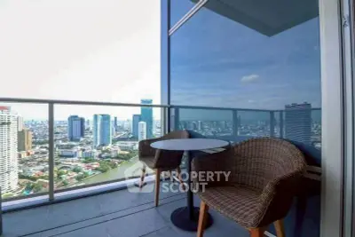 Stunning city view from modern balcony with cozy seating area.