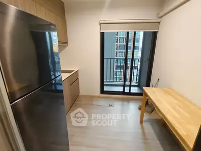 Modern kitchen with sleek fridge and balcony view in urban apartment