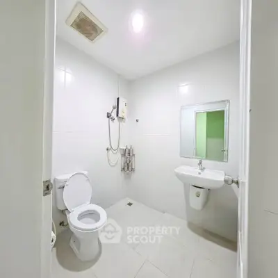Spacious modern bathroom with sleek white tiles and contemporary fixtures.