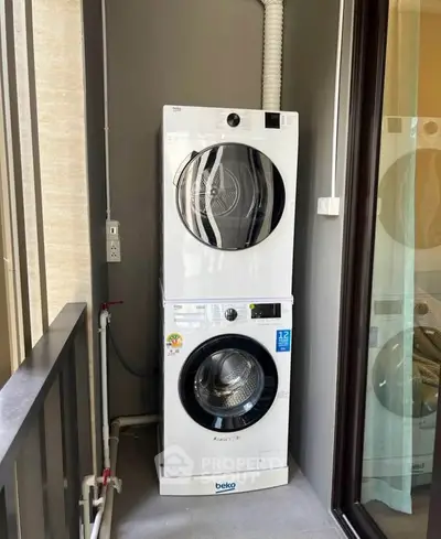 Modern stacked washer and dryer on a balcony in a contemporary apartment.