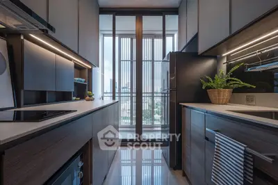 Modern kitchen with sleek cabinetry and large windows offering city views.