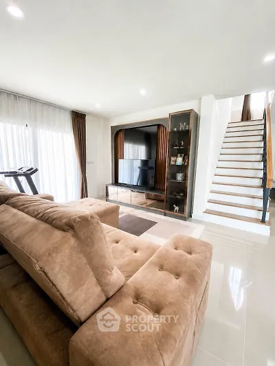 Spacious living room with modern decor and staircase in a stylish home