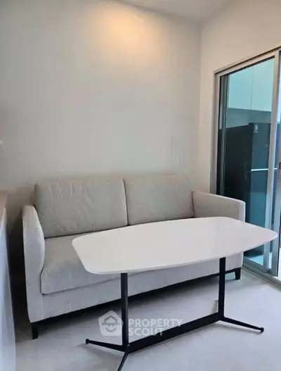 Modern living room with sleek sofa and stylish table near sliding glass doors.