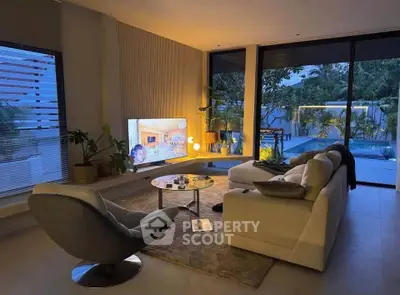 Luxurious living room with modern decor and pool view, perfect for relaxation and entertainment.