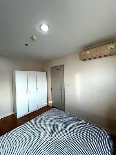 Cozy bedroom with air conditioning and wardrobe in modern apartment