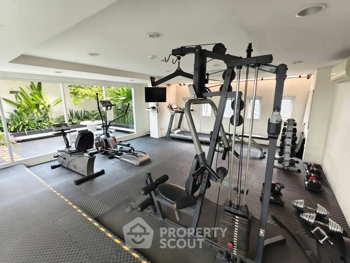 Modern home gym with state-of-the-art equipment and lush garden view.