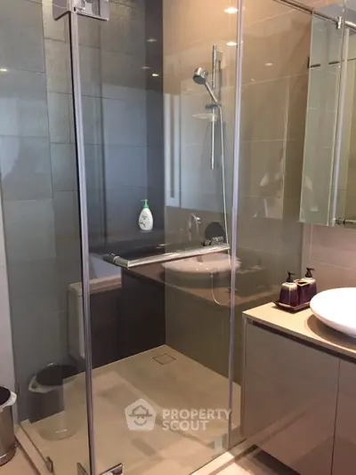 Modern bathroom with glass shower enclosure and sleek vanity.