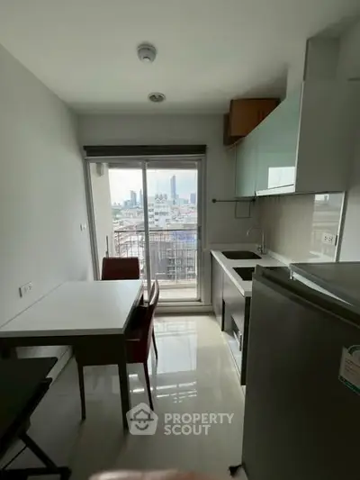 Modern kitchen with city view, sleek appliances, and dining area in a compact space.