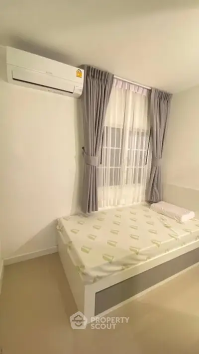 Cozy bedroom with air conditioning and elegant curtains, perfect for relaxation.