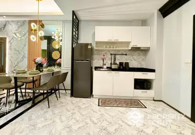 Modern kitchen with dining area featuring marble flooring and stylish lighting