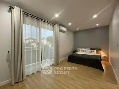 Spacious modern bedroom with large window and stylish decor