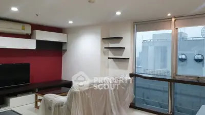 Modern living room with large window and city view, featuring sleek furniture and stylish shelving.