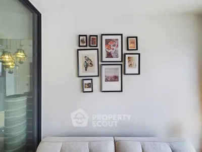 Stylish living room with modern art gallery wall and cozy sofa, perfect for relaxation and entertaining.