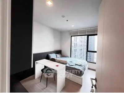 Modern bedroom with city view, featuring a cozy bed and sleek study desk, perfect for urban living.