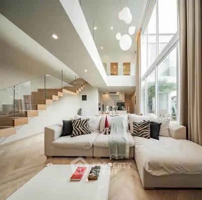 Luxurious modern living room with high ceilings and elegant staircase