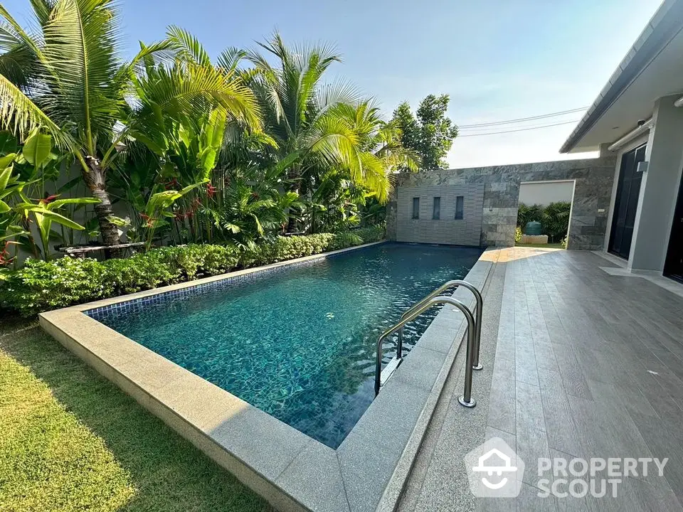 Luxurious private pool surrounded by lush greenery in a modern villa setting.