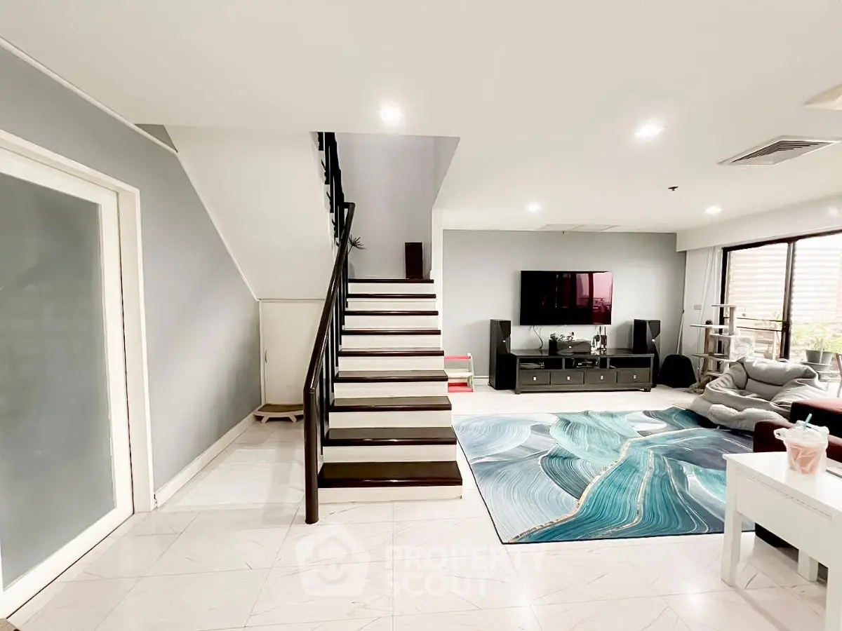 Spacious modern living room with stylish staircase and vibrant decor
