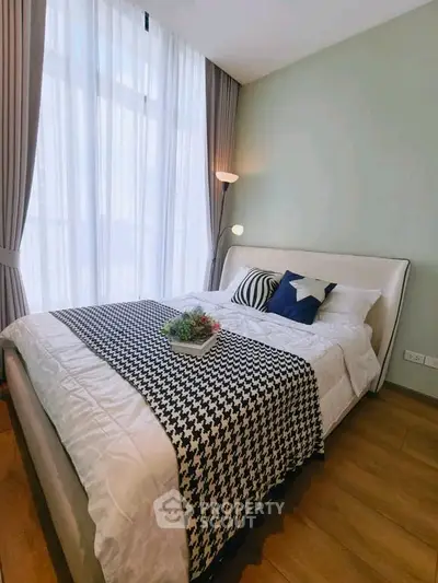 Cozy bedroom with stylish decor and large window for natural light