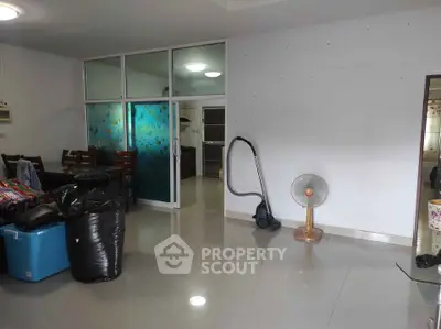 Spacious living room with modern furniture and glass partition, ideal for family gatherings.