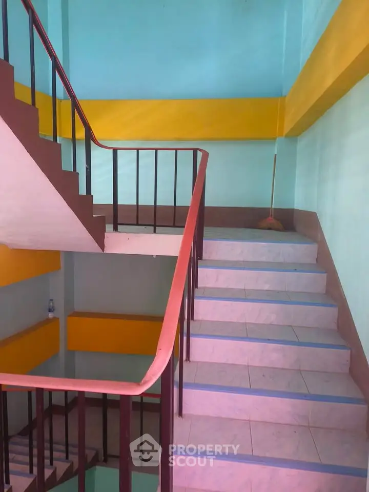 Brightly painted stairwell with colorful walls and railings in a residential building.