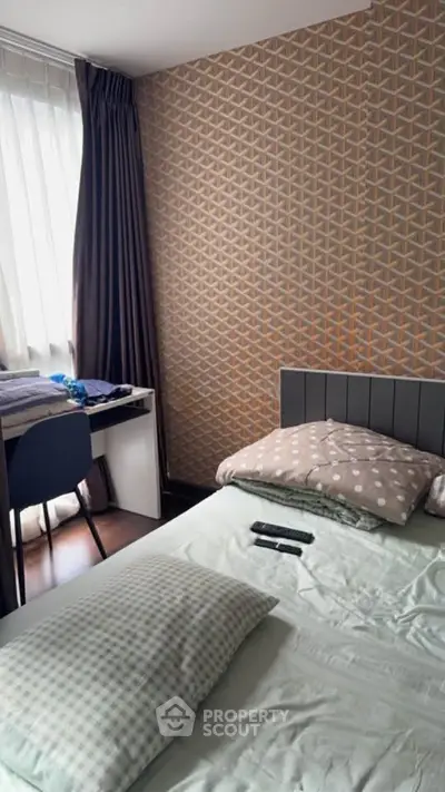 Cozy bedroom with modern geometric wallpaper and natural light