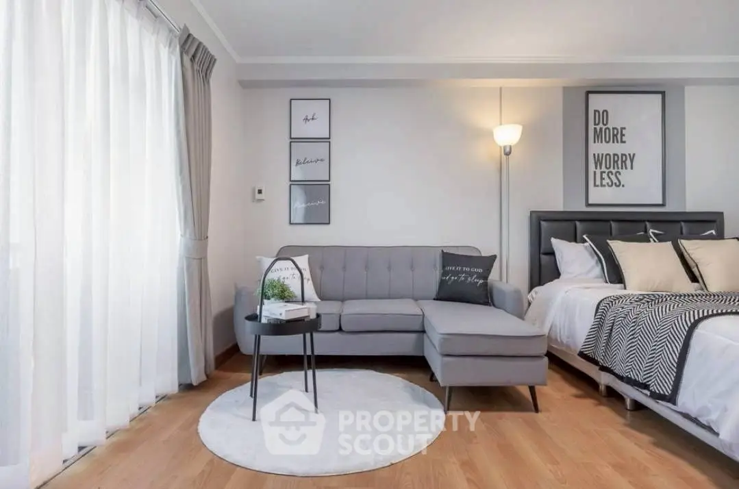 Modern living room with stylish decor and cozy seating area next to a comfortable bed.