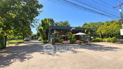 Charming single-story building surrounded by lush greenery and spacious driveway.