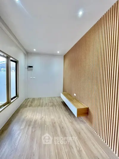 Modern minimalist room with wooden accent wall and large window