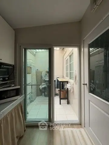 Cozy interior with sliding glass door leading to a small balcony, featuring modern appliances and natural light.