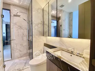 Luxurious modern bathroom with marble walls and sleek fixtures in a high-end apartment.
