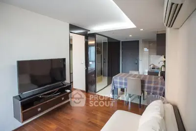 Modern living room with wooden flooring and sleek TV setup in a stylish apartment.
