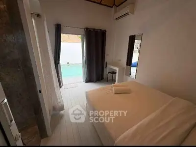Cozy bedroom with pool view, featuring modern decor and natural light.