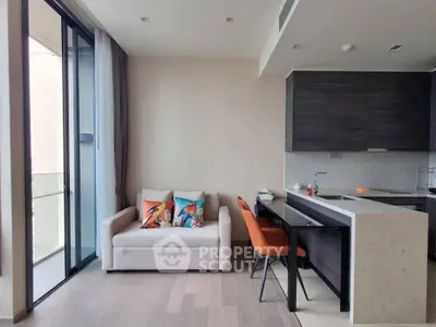 Modern open-plan living room with sleek kitchen and balcony access