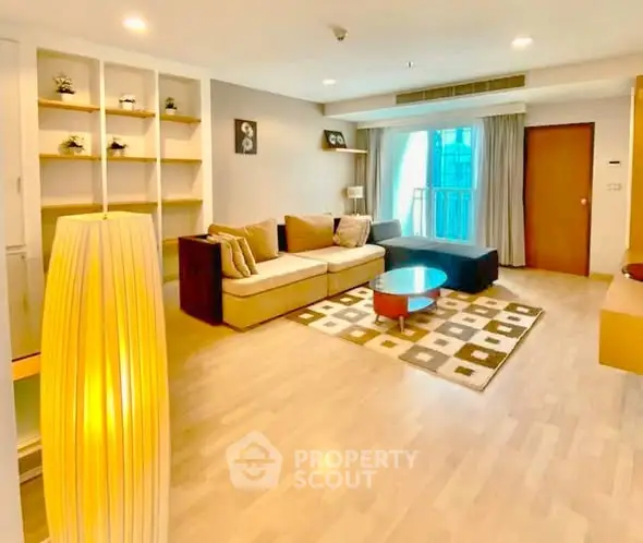 Spacious living room with modern decor and large windows in a stylish apartment.