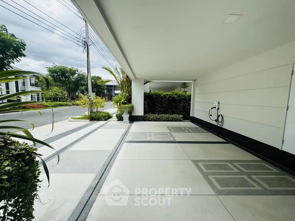 Modern residential parking area with sleek design and lush greenery.