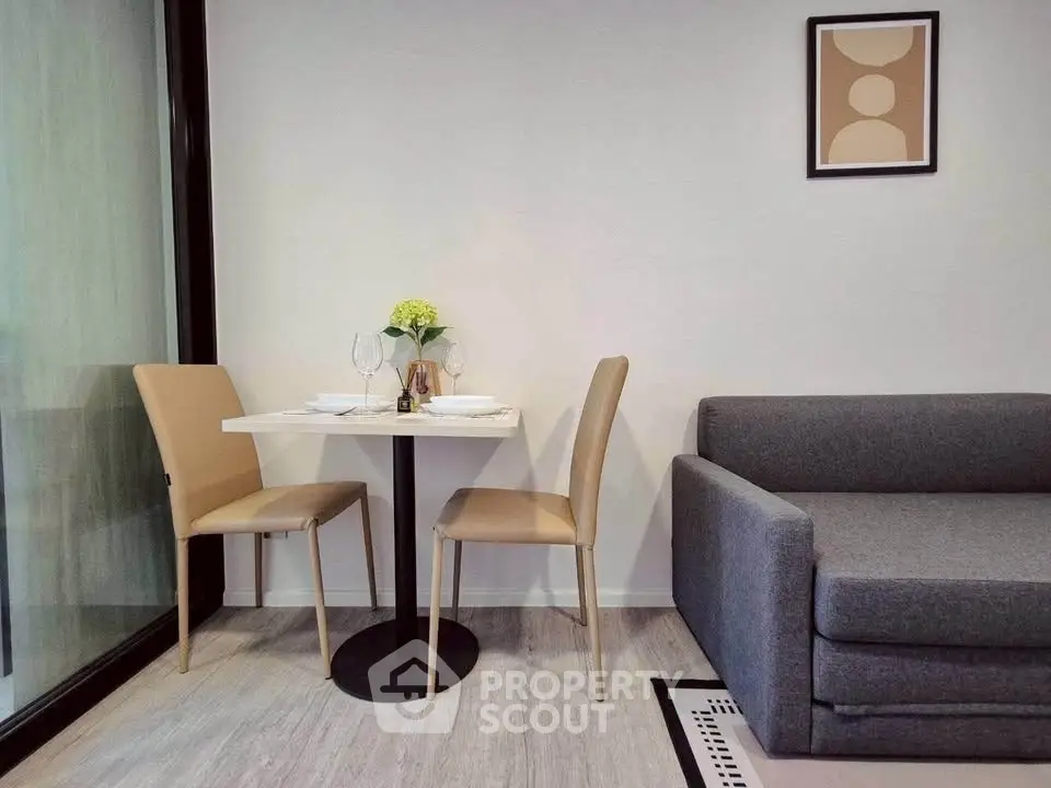 Modern dining area with stylish table and chairs next to a cozy gray sofa, perfect for compact living spaces.