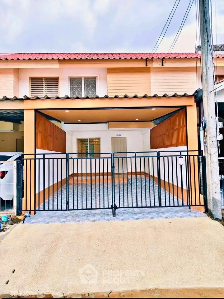 Charming two-story townhouse with gated entrance and tiled driveway, perfect for modern living.