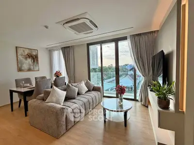 Spacious modern living room with large windows and stylish decor in a high-rise apartment.