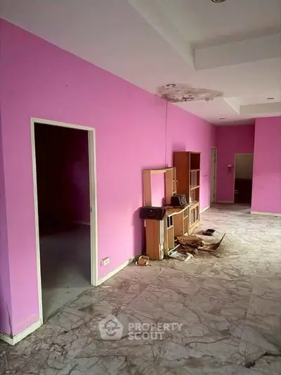 Spacious interior with vibrant pink walls and marble flooring, ideal for creative renovation.