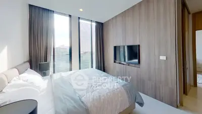 Modern bedroom with large windows and wall-mounted TV in luxury apartment
