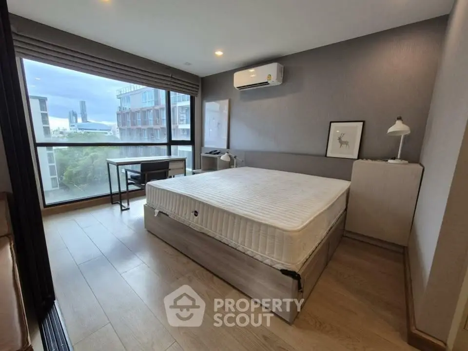 Modern bedroom with large window and stylish decor in urban apartment