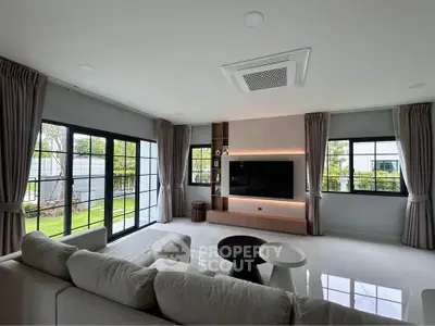 Spacious modern living room with large windows and garden view, featuring elegant furniture and stylish decor.