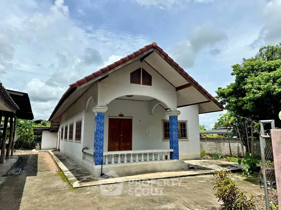 Charming single-story house with blue accents and spacious front yard, perfect for family living.